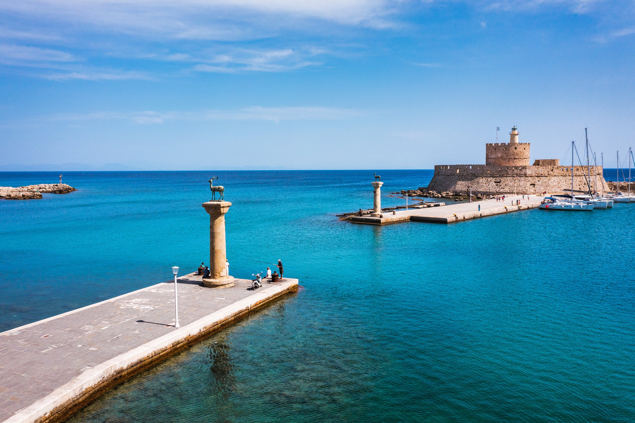 Mandraki port with deers statue, where The Colossus was standing and fort of St. Nicholas. Rhodes, Greece. Hirschkuh statue in the place of the Colossus of Rhodes, Rhodes, Greece